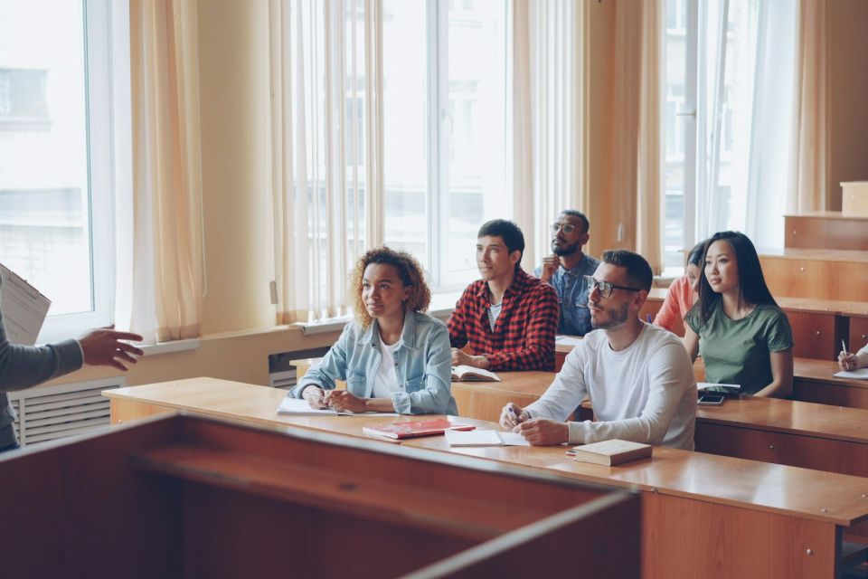 Lehrer erklärt einer Gruppe junger Erwachsener den Unterrichtsstoff